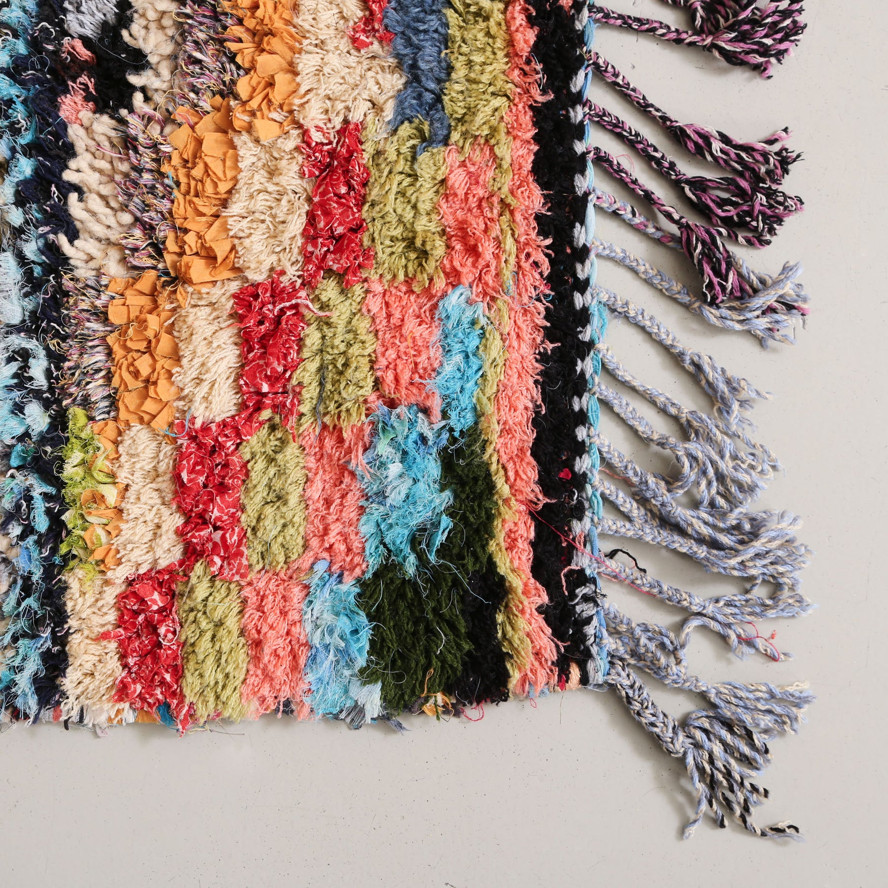 angolo di un tappeto boucherouite vintage con la frangia dai diversi colori
