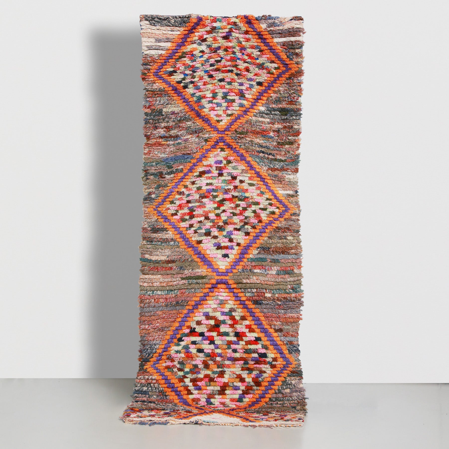 tappeto boucherouite vintage realizzato a mano con vecchi tessuti e filati a creare dei rombi dai bordi arancioni e violi s