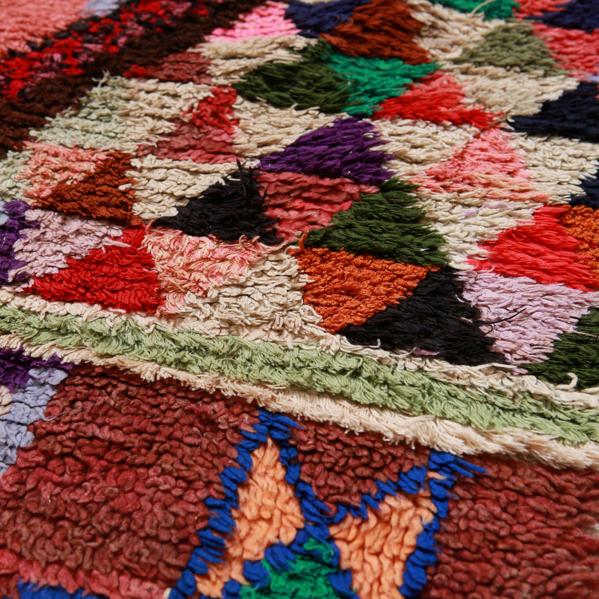 Dettaglio texture tappeto boucherouite vintage con lavorazione artigianale in lana multicolore e motivi geometrici marocchini