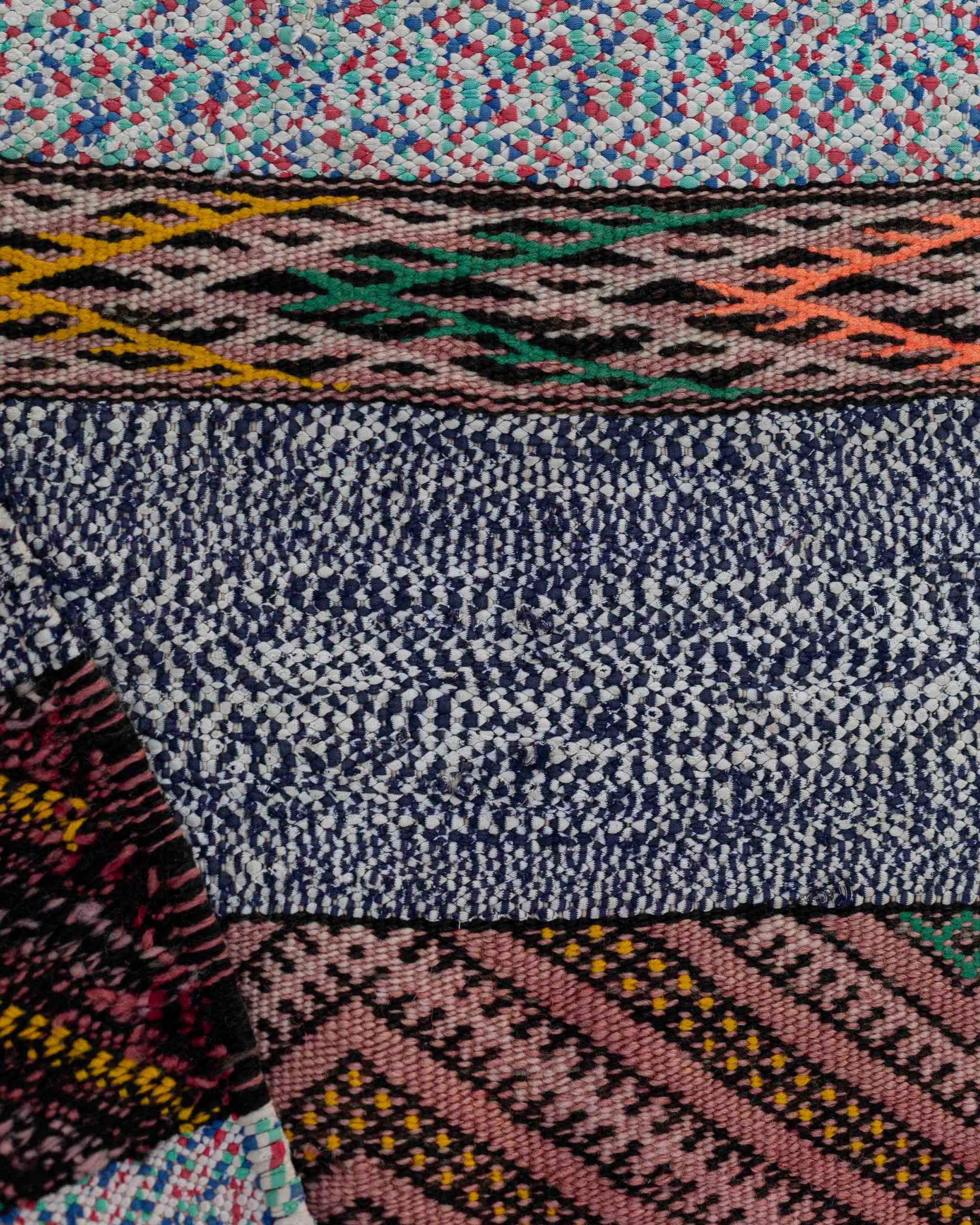 Dettaglio del tappeto boucherouite vintage multicolore in tessuti riciclati, con righe a puntini o decori geometrici