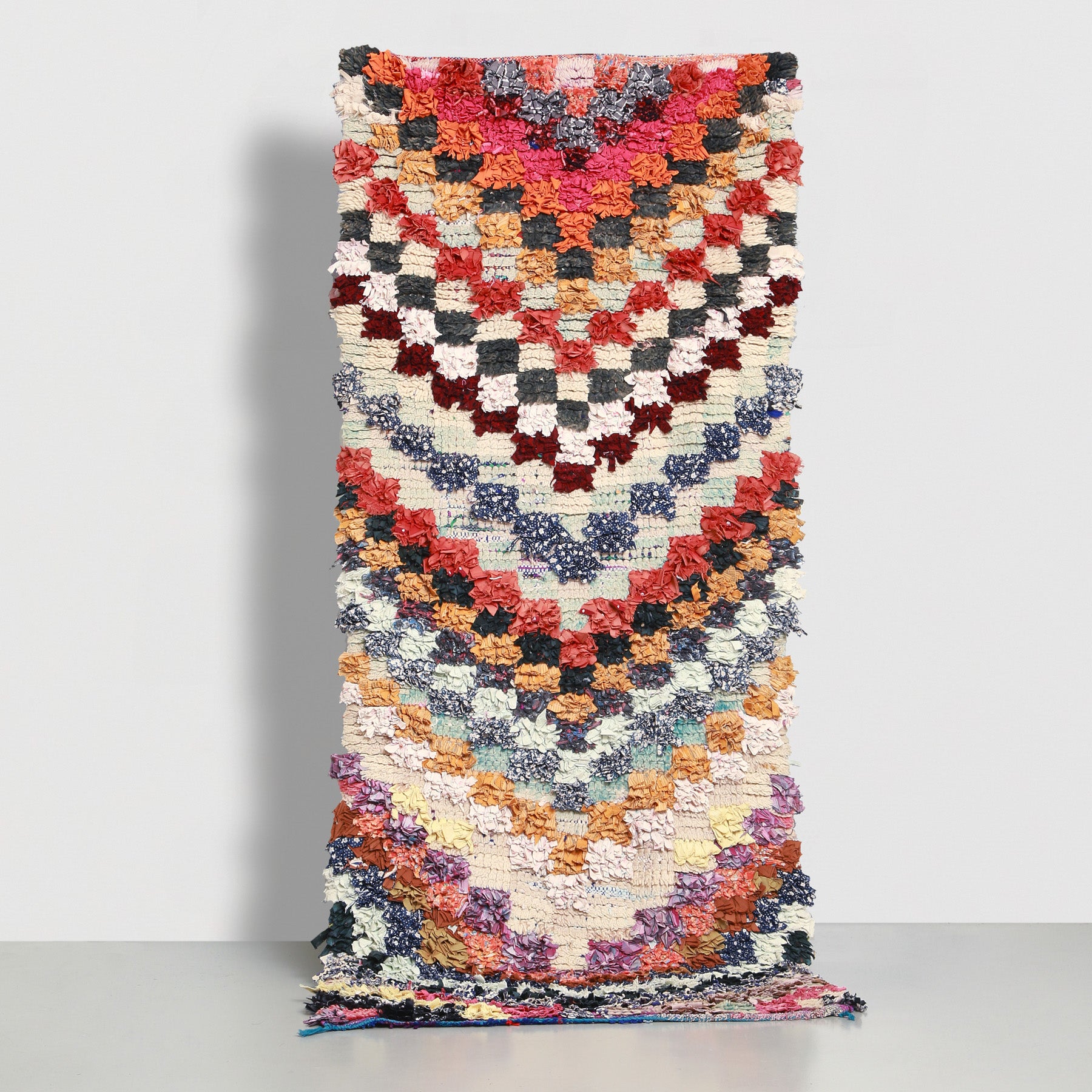 tappeto boucherouite fatto con stracci di tessuto e lana annodati che creano dei quadrati colorati che compongono delle frecce