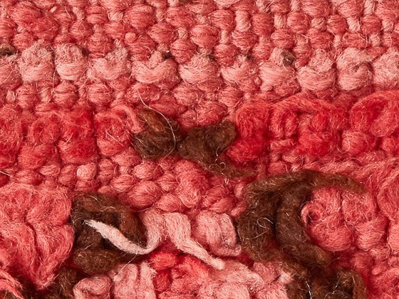 Dettaglio di un tappeto sulle tinte del rosa con alcuni inserti marroni
