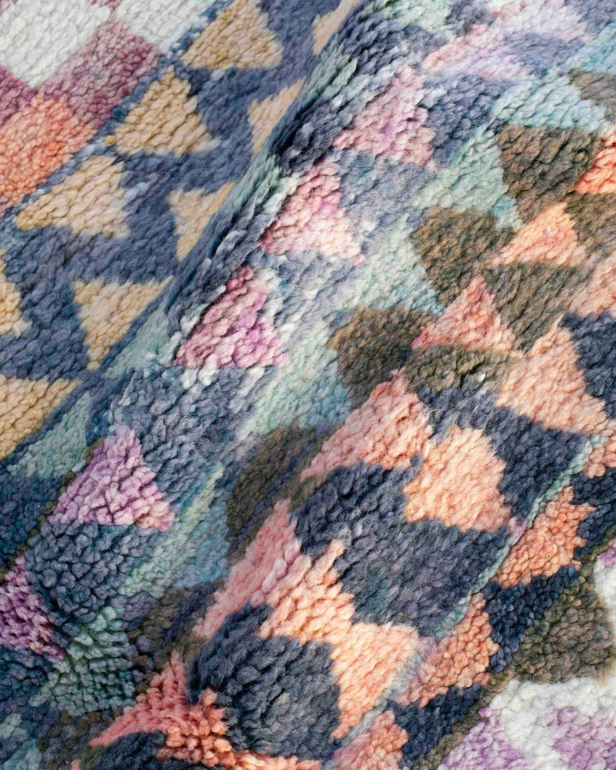 Dettaglio del vello del tappeto Beni Ourain con triangoli blu, rosa, gialli e verde oliva
