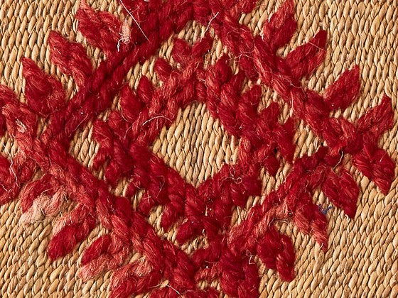 Dettaglio tappeto con decorazione romboidale rossa su sfondo ocra