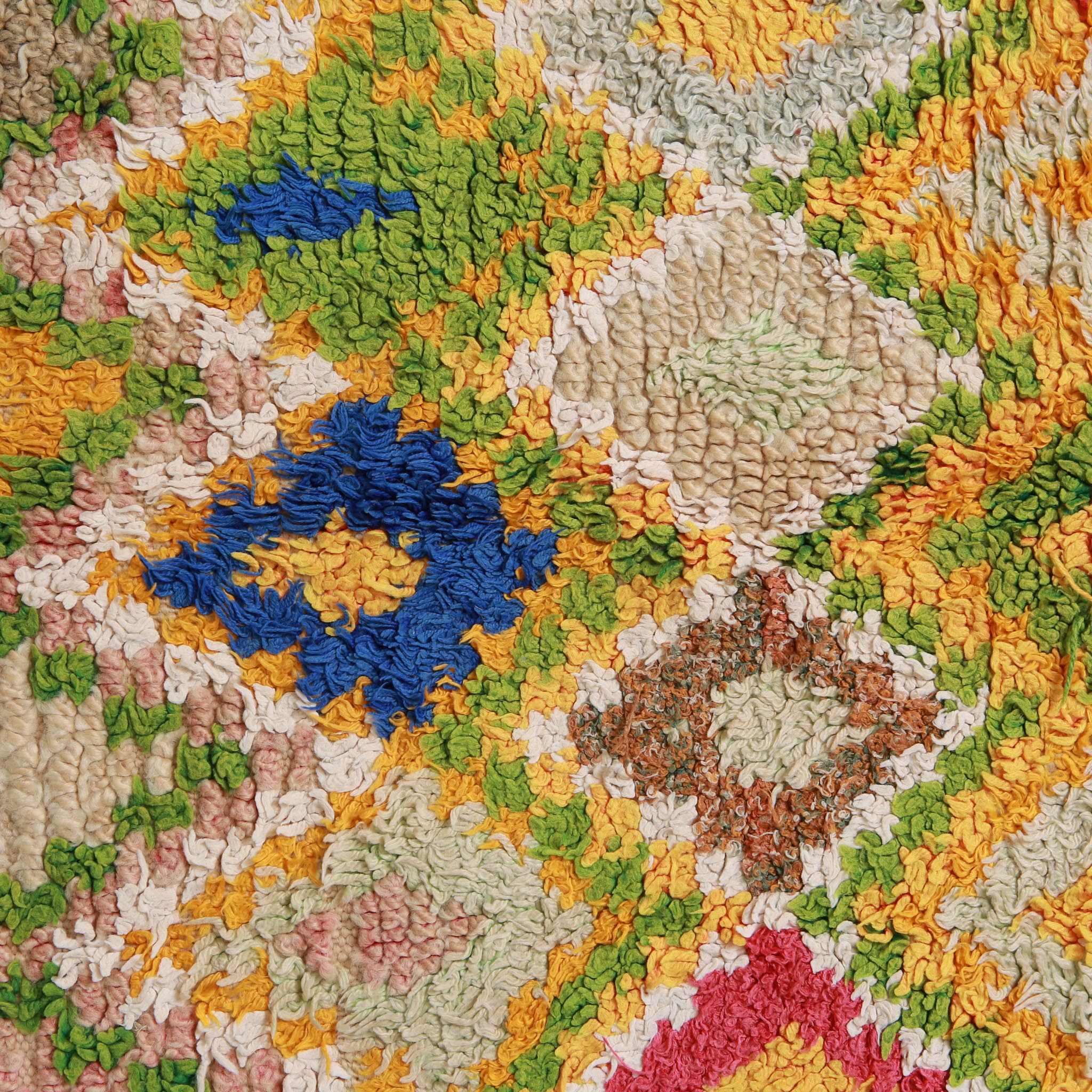 Immagine ravvicinata del motivo geometrico del tappeto Marmoucha con dettaglio dei colori vibranti: giallo ocra, verde, blu royal e rosa corallo