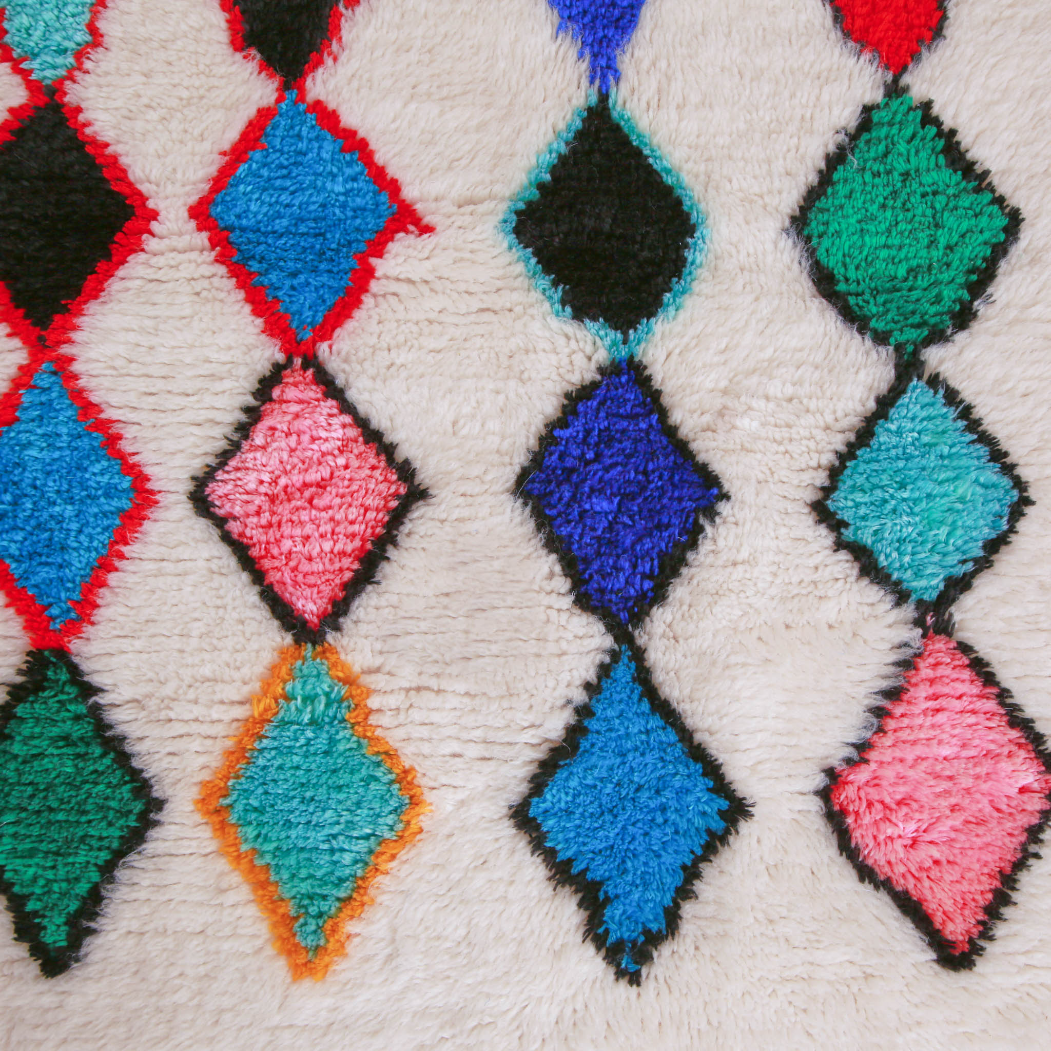 dettaglio dei rombi di in tappetto marocchino con bordo giallo nero e rosso e interno blu azzurro rosa verde nero