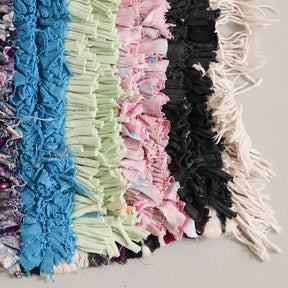angolo di tappeto boucherouite con bande in stracci di vecchi tessuti annodati neri,  rosa, verdi e azzurri