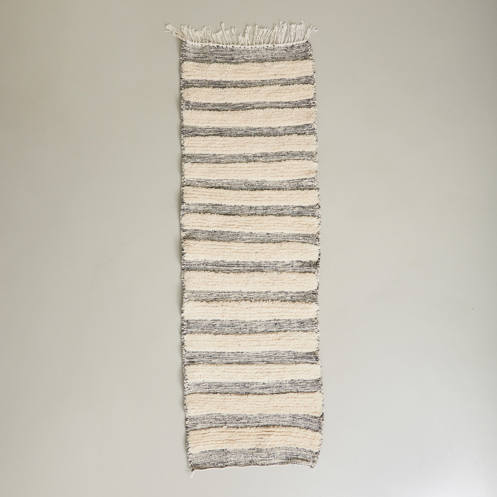 tappeto passatoia boujaad realizzato a mano con bande di lana bianca annodata e bande grigie tessute disteso su pavimento