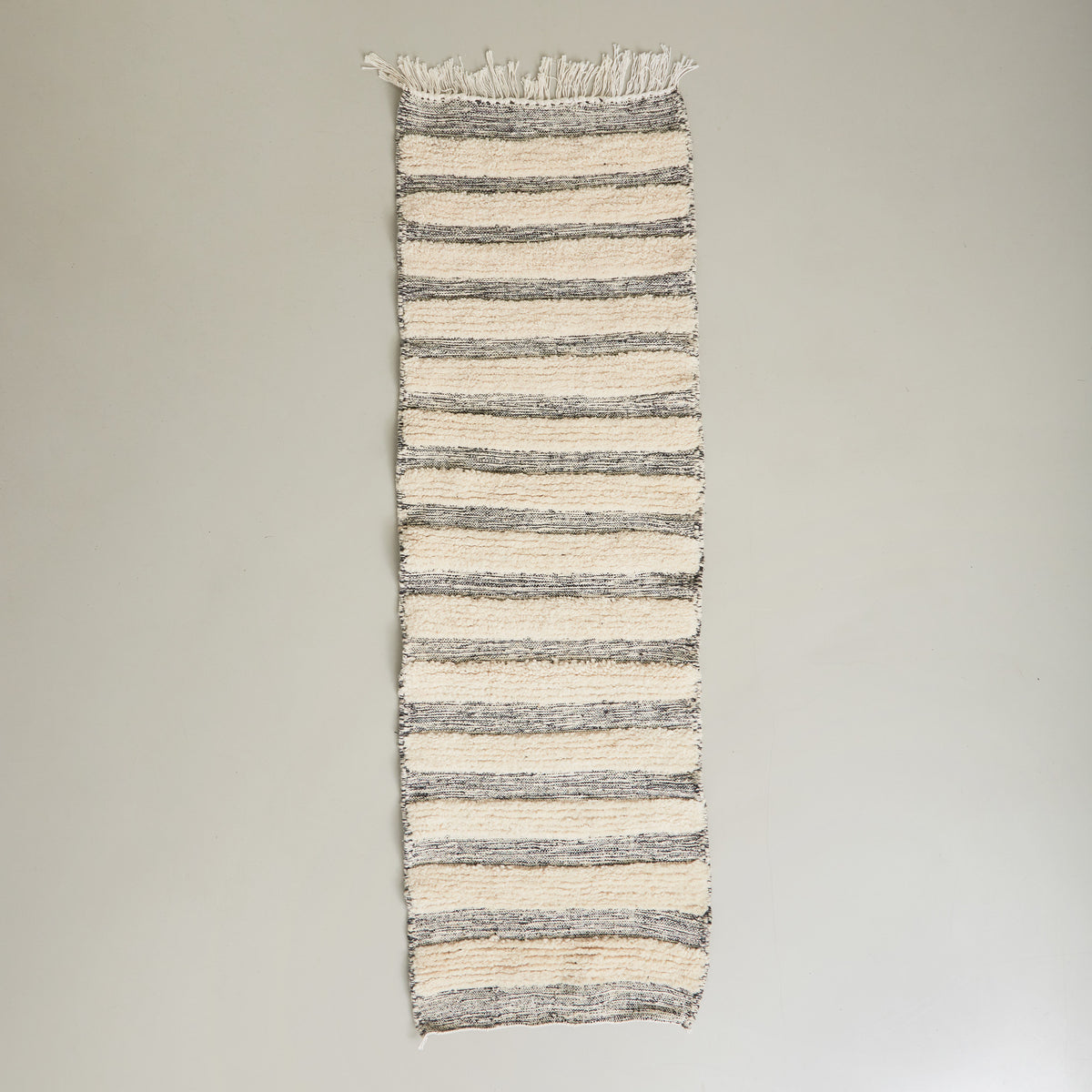 tappeto passatoia boujaad realizzato a mano con bande di lana bianca annodata e bande grigie tessute disteso su pavimento