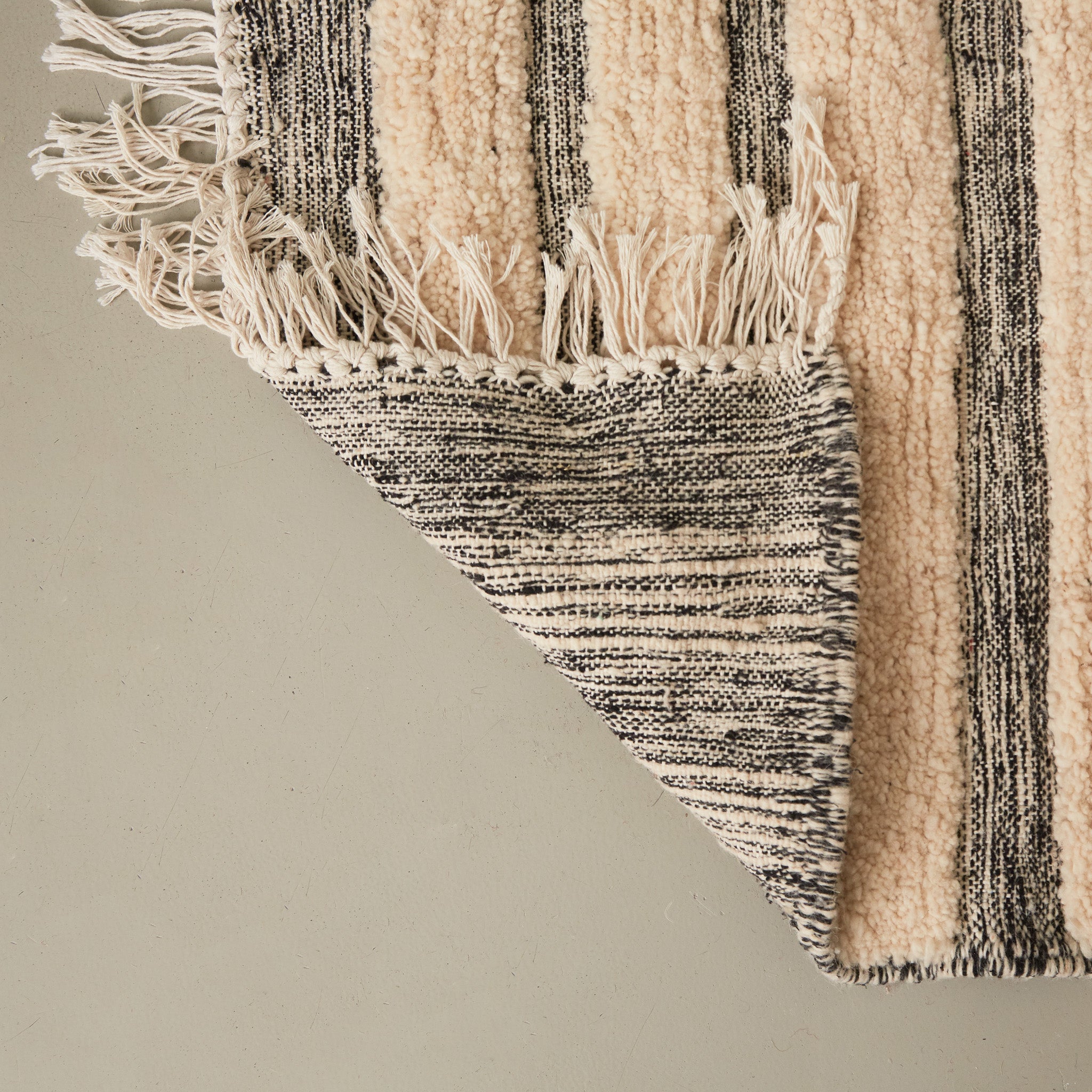 dettaglio del retro di un tappeto passatoia boujaad realizzato a mano con bande di lana bianca annodata e bande grigie tessute