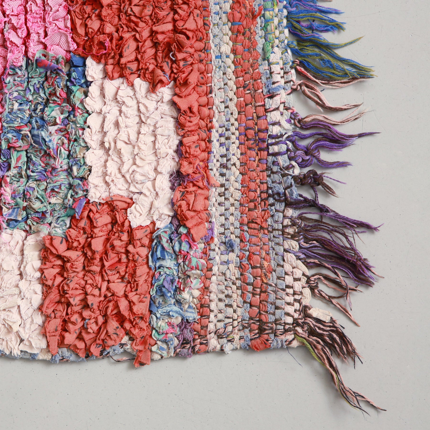 angolo e frangia di un tappeto boucherouite vintage realizzati con annodando fettuccine di vecchi tessuti