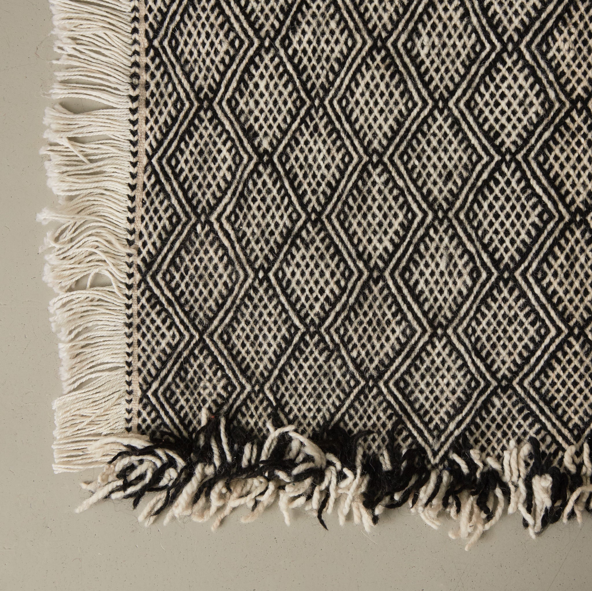 angolo e frangia di un tappeto zanafi passatioa stile kilim realizzato intrecciando lana bianca e nera