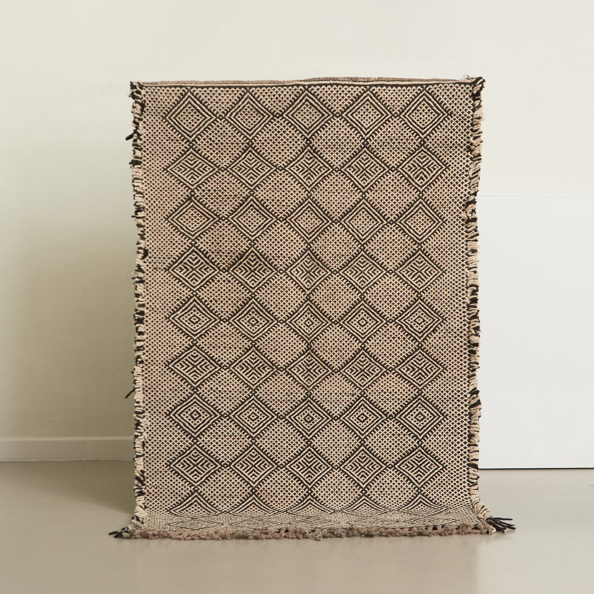 tappeto zanafi piccolo con disegni tradizioni a rombi realizzato intrecciando lana di colore nero e bianco appeso
