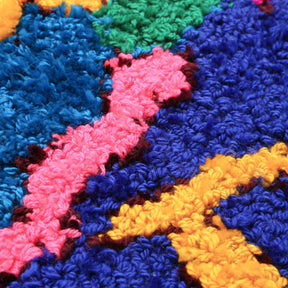 dettaglio del tessuto di un tappeto zindekh dai colori viola giallo e rosa