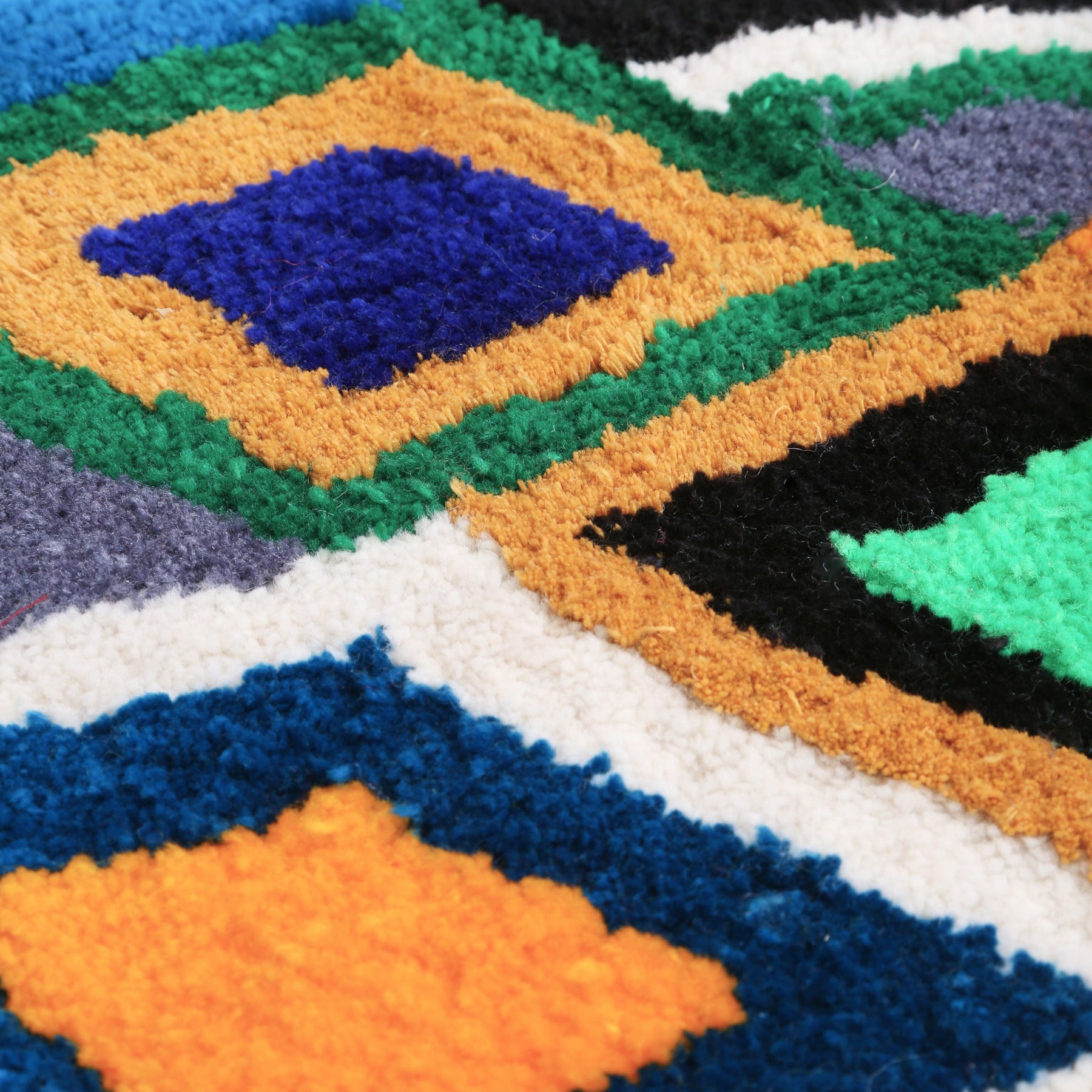 dettaglio dei filo tosato di un tappeto zindekh con rombi colorati