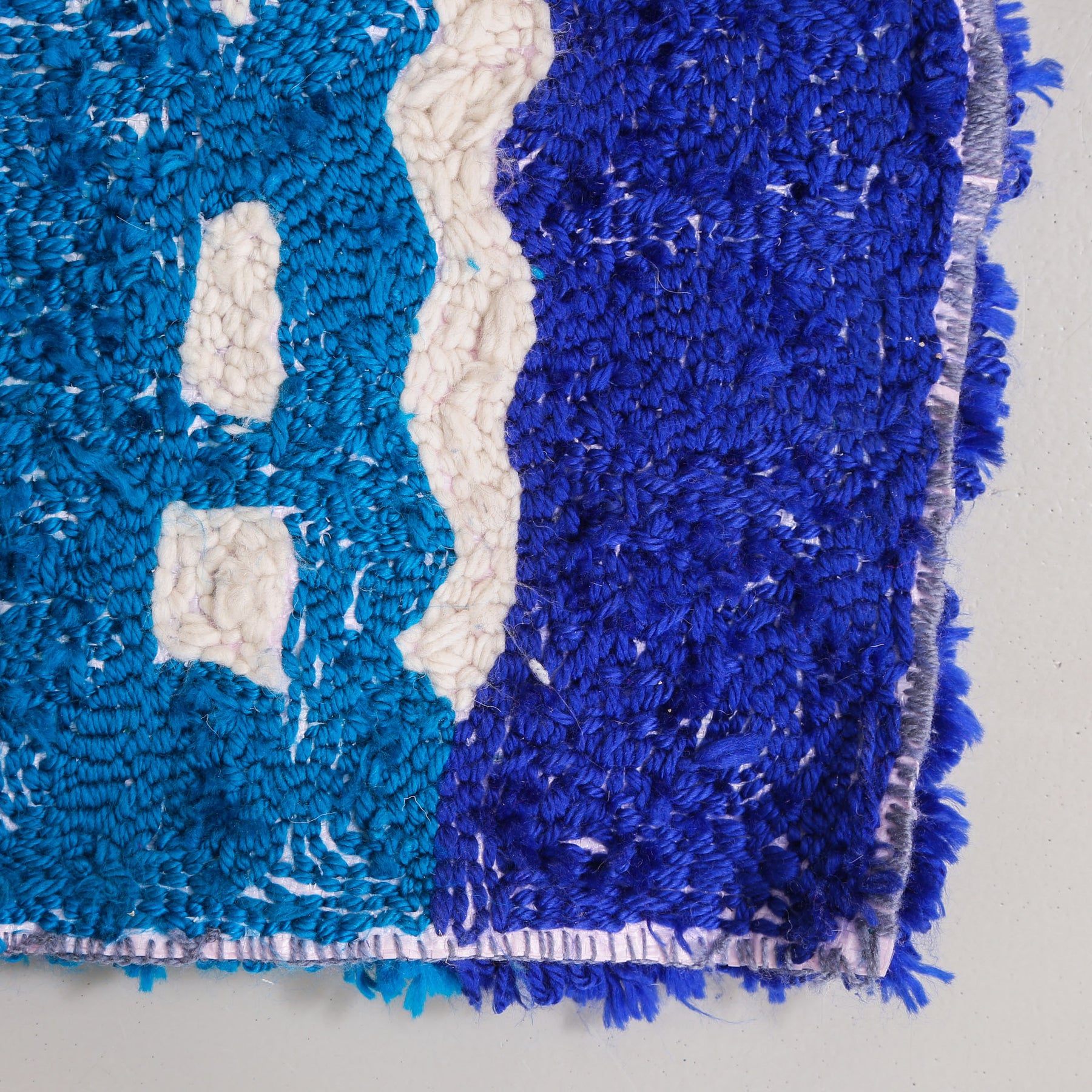 retro di un tappeto zyndekh con tessuto blu e azzurro e bianco su sacchetto di plastica riciclato