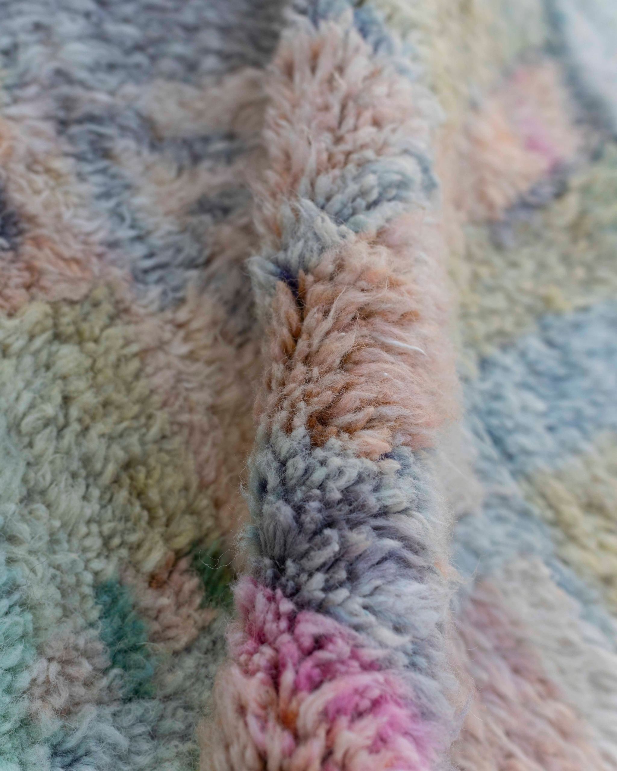 Texture ravvicinata del tappeto Beni Ourain multicolore con vello morbido e sfumature pastello