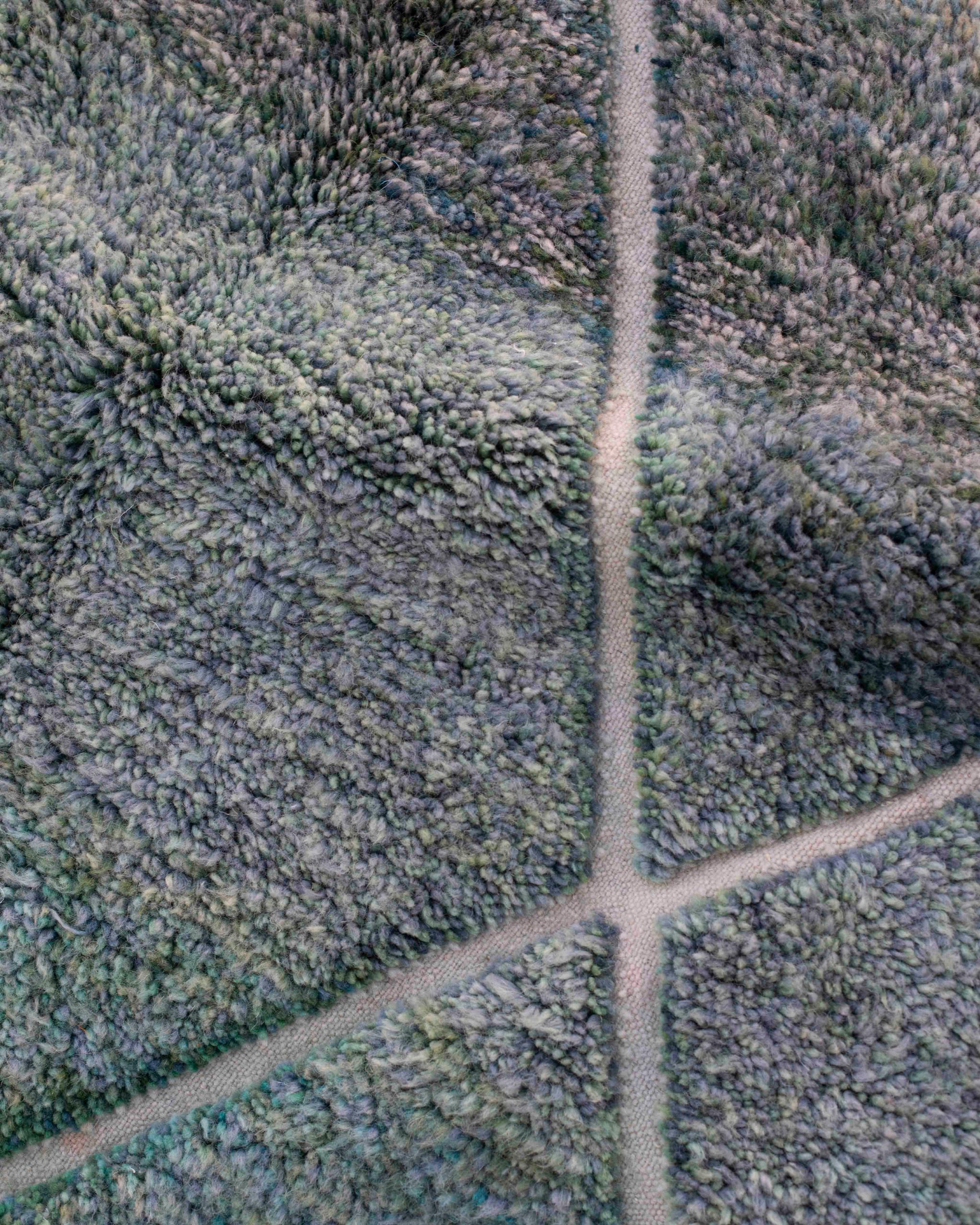 Texture ravvicinata del tappeto Beni Ourain con vello mélange verde-blu e  pattern a rombi