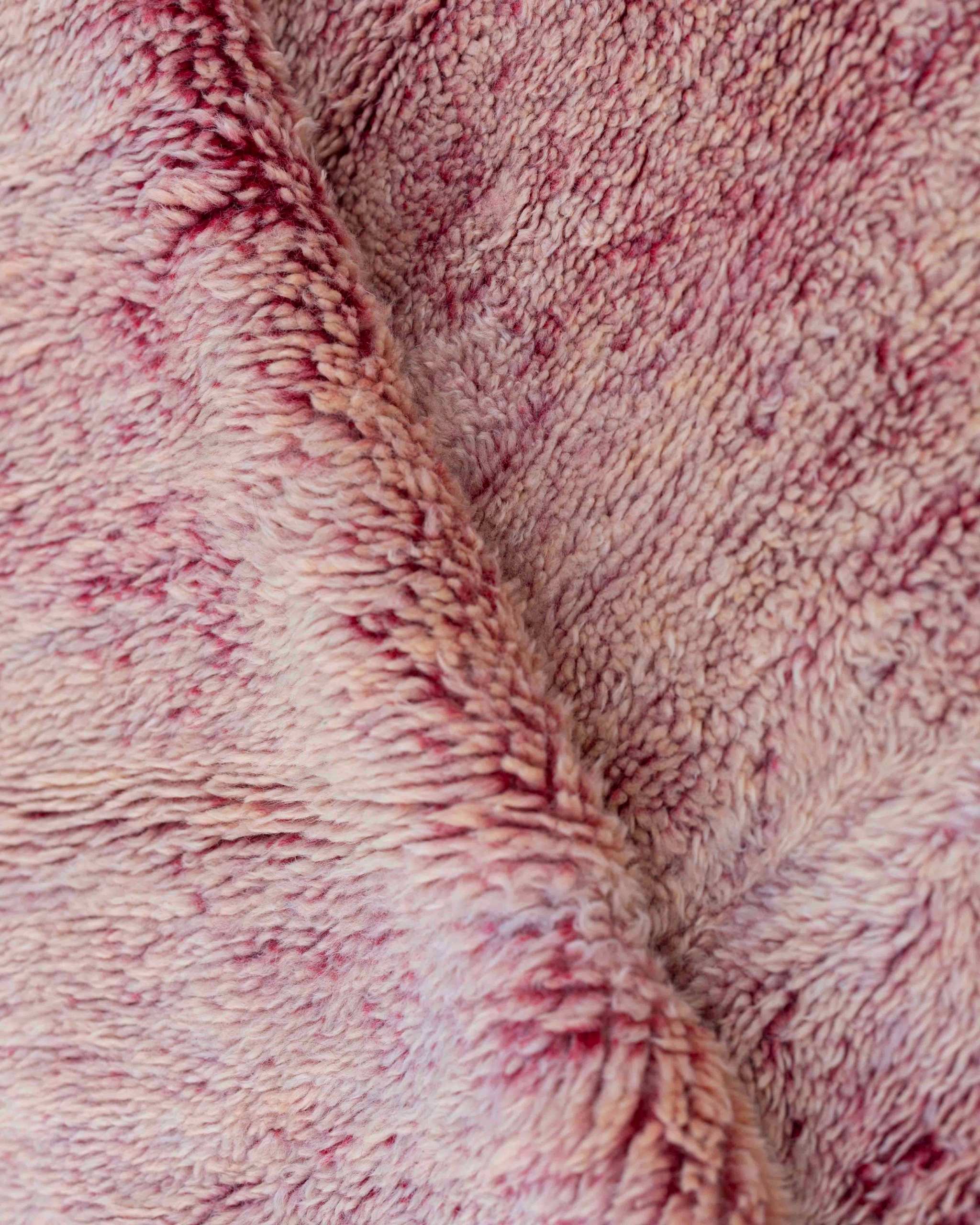 Texture ravvicinata del tappeto Beni Mrirt rosa con pelo medio fitto e variazioni cromatiche nella tintura della lana