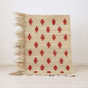piccola stuoia hassira intrecciata con paglia di palma e ricamata con simboli in lana rossa