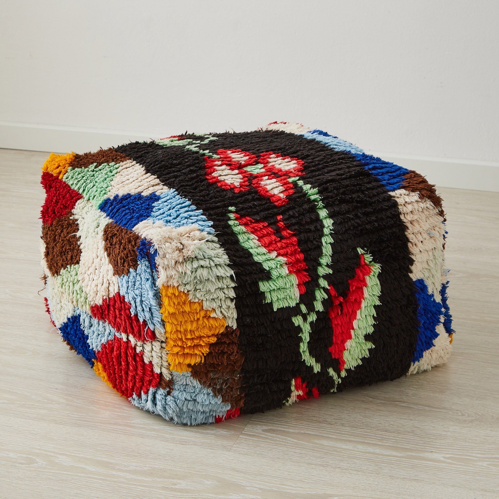 pouf vintage boucherouite con motivo floreale a centro e forme gemotrice colorate sui lati