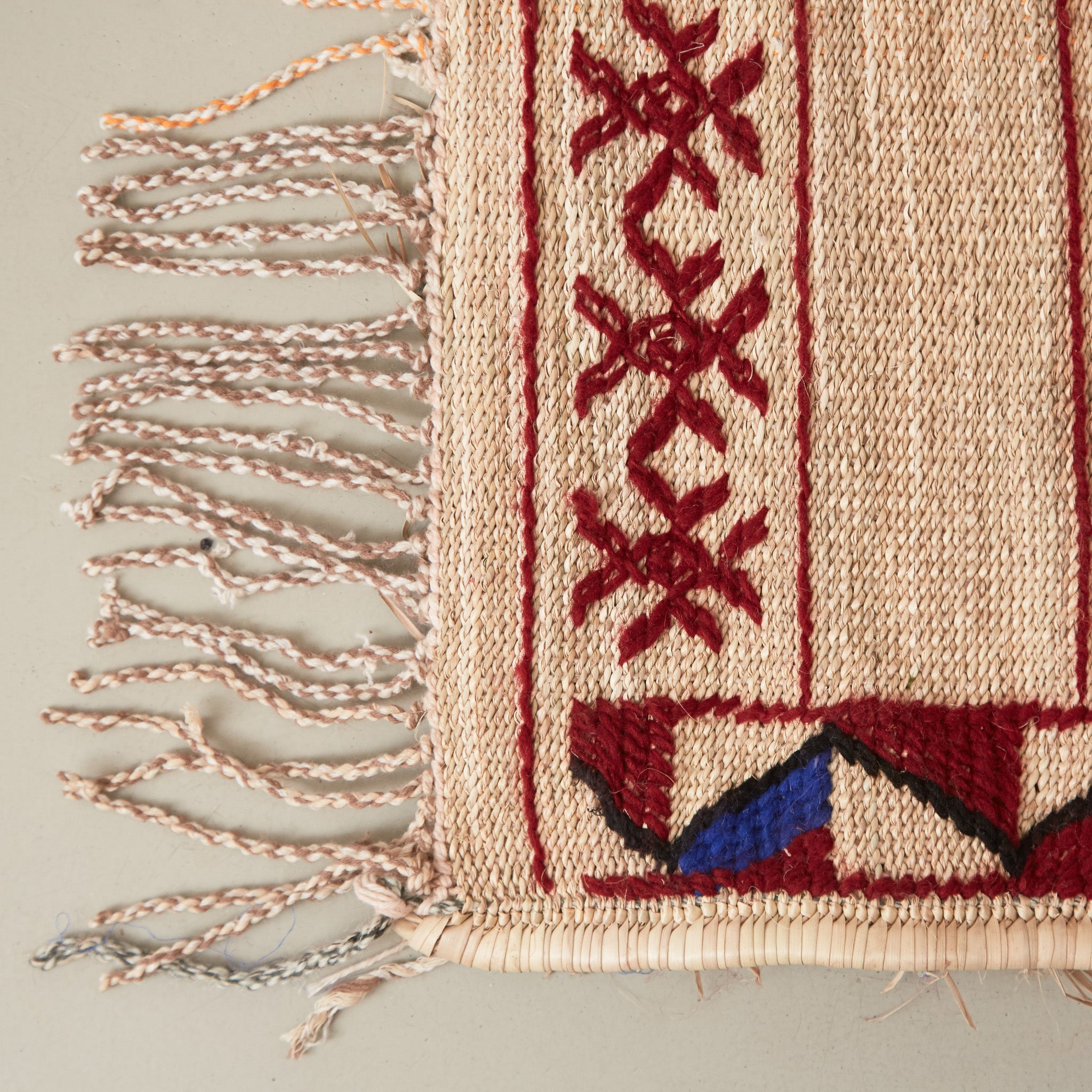dettaglio dell'angolo e della frangia di una stuoia tappeto in paglia hassira grande in paglia di palma e ricami in lana
