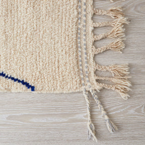 morbido tappeto azilal per cameretta con disegni geometriche e linee di diverse colori su base bianca dettaglio della frangia