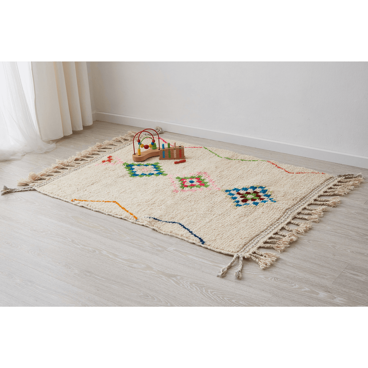 morbido tappeto azilal per cameretta con disegni geometriche e linee di diverse colori su base bianca disteso sul pavimento