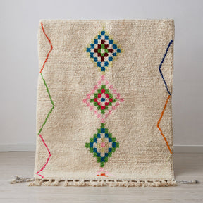 morbido tappeto azilal per cameretta con disegni geometriche e linee di diverse colori su base bianca in posizione verticale