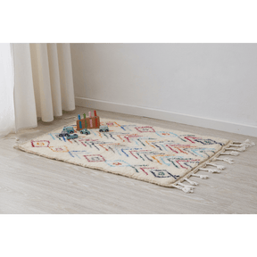 tappeto azilal per cameretta con rombi e linee spezzate simili a frecce di diversi colori disteso sul pavimento