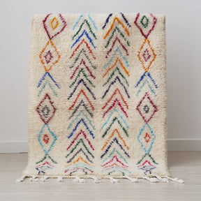tappeto azilal per cameretta con rombi e linee spezzate simili a frecce di diversi colori posizionato in verticale