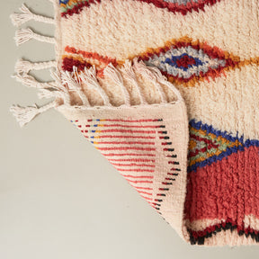 dettaglio del retro di un tappeto azilal piccolo con tre file di rombi colorati su base in lana bianca