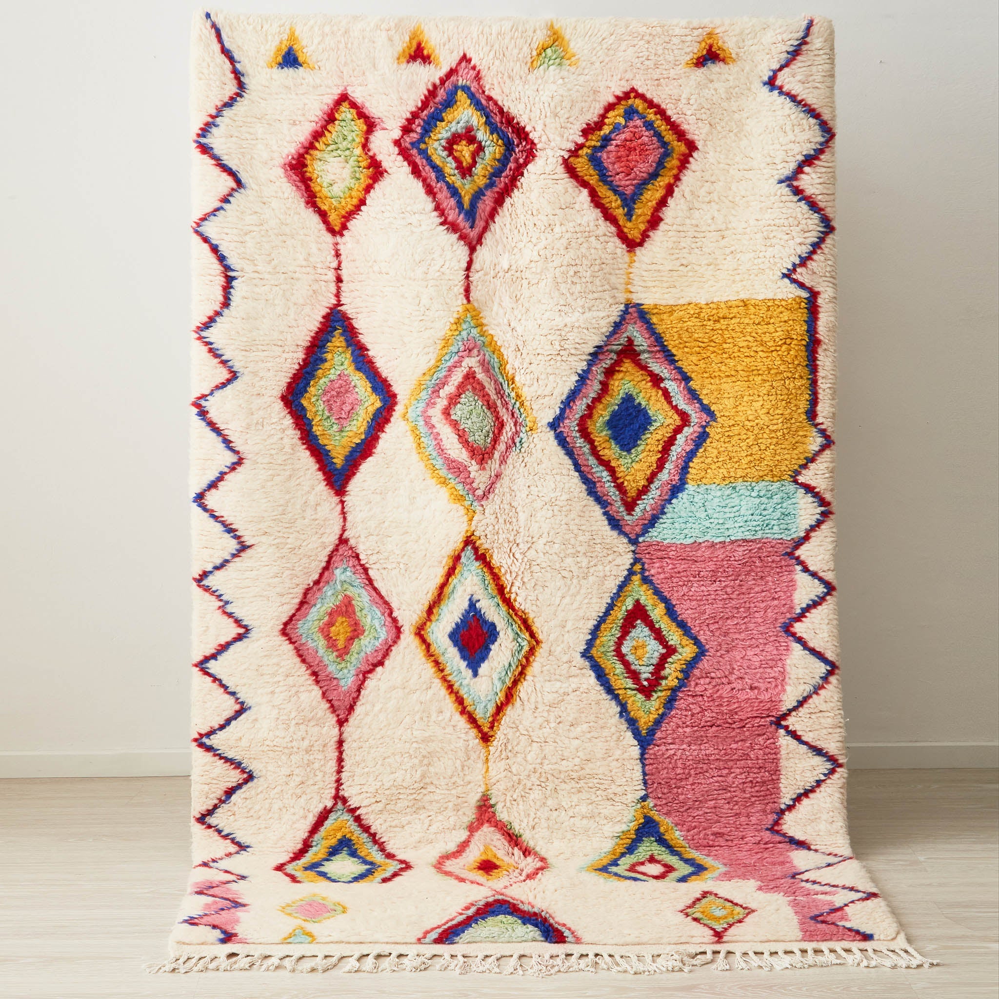 tappeto azilal con rombi e linee dai colori vivaci su base bianca posizionato in verticale
