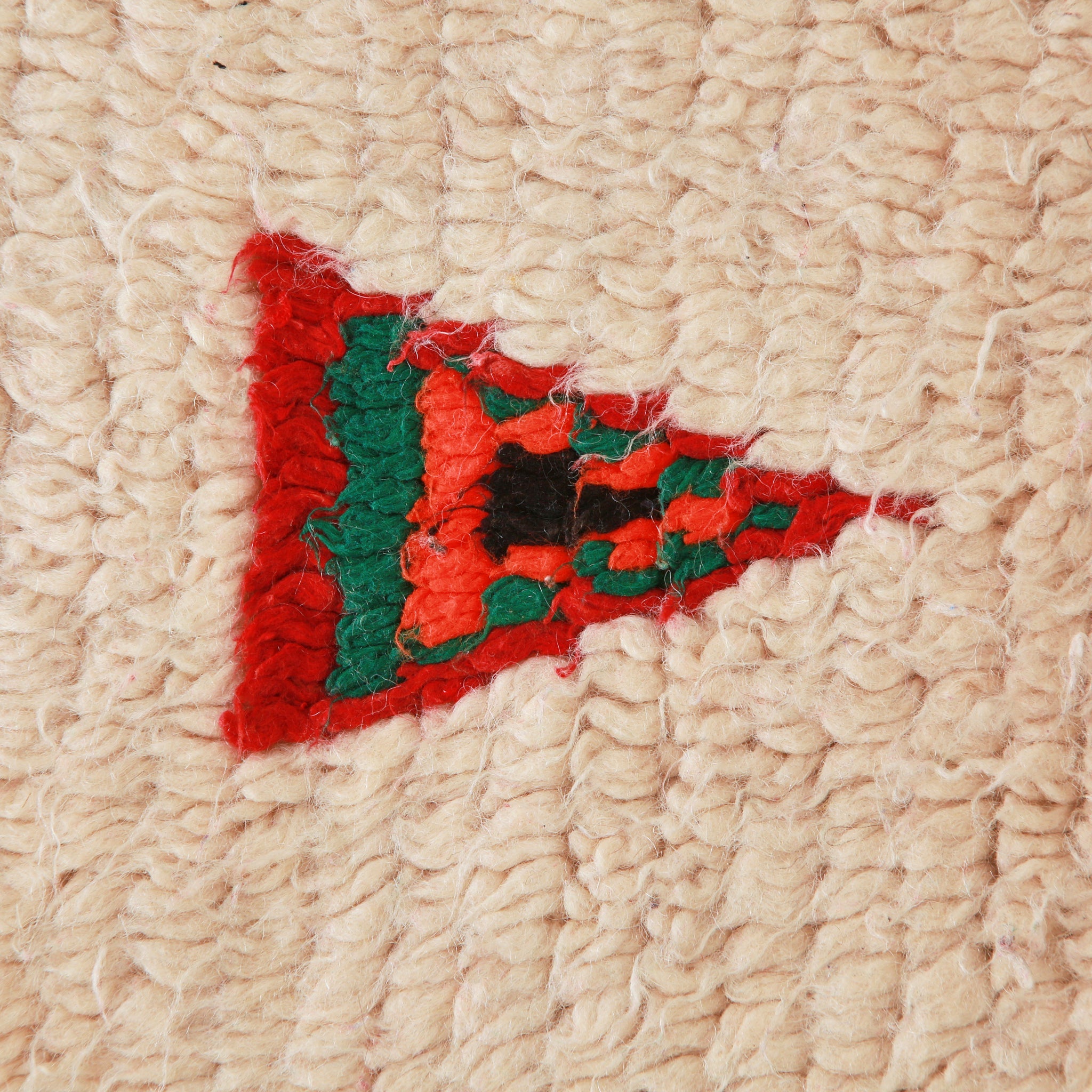 dettaglio ravvicinato della lana e di un triangoli sovrapposti di colore rosso,verde,arancione e nero