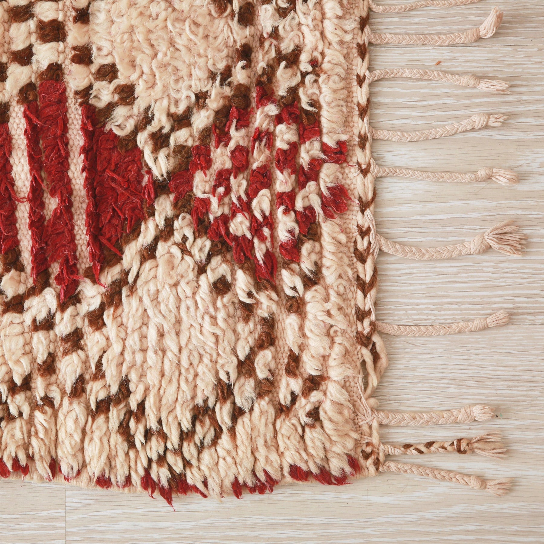 angolo del tappeto vintage che mostra i peli della lana un po consumati e la frangia