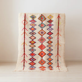tappeto azilal vintage con tre colonne di rombi colorati su base bianca.