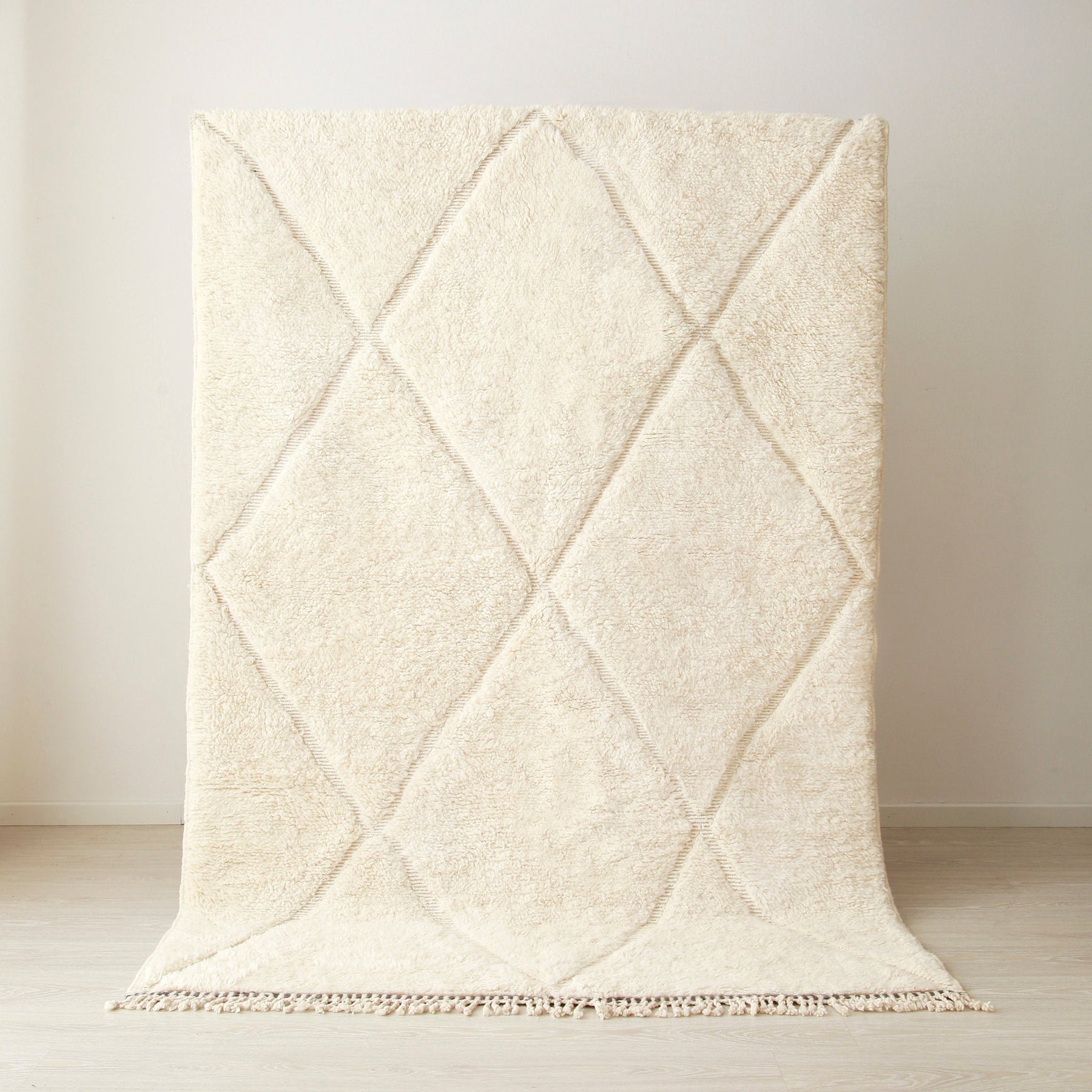 tappeto beni mrirt appeso realizzato in lana bianca con righe bianche che creano dei rombi.
