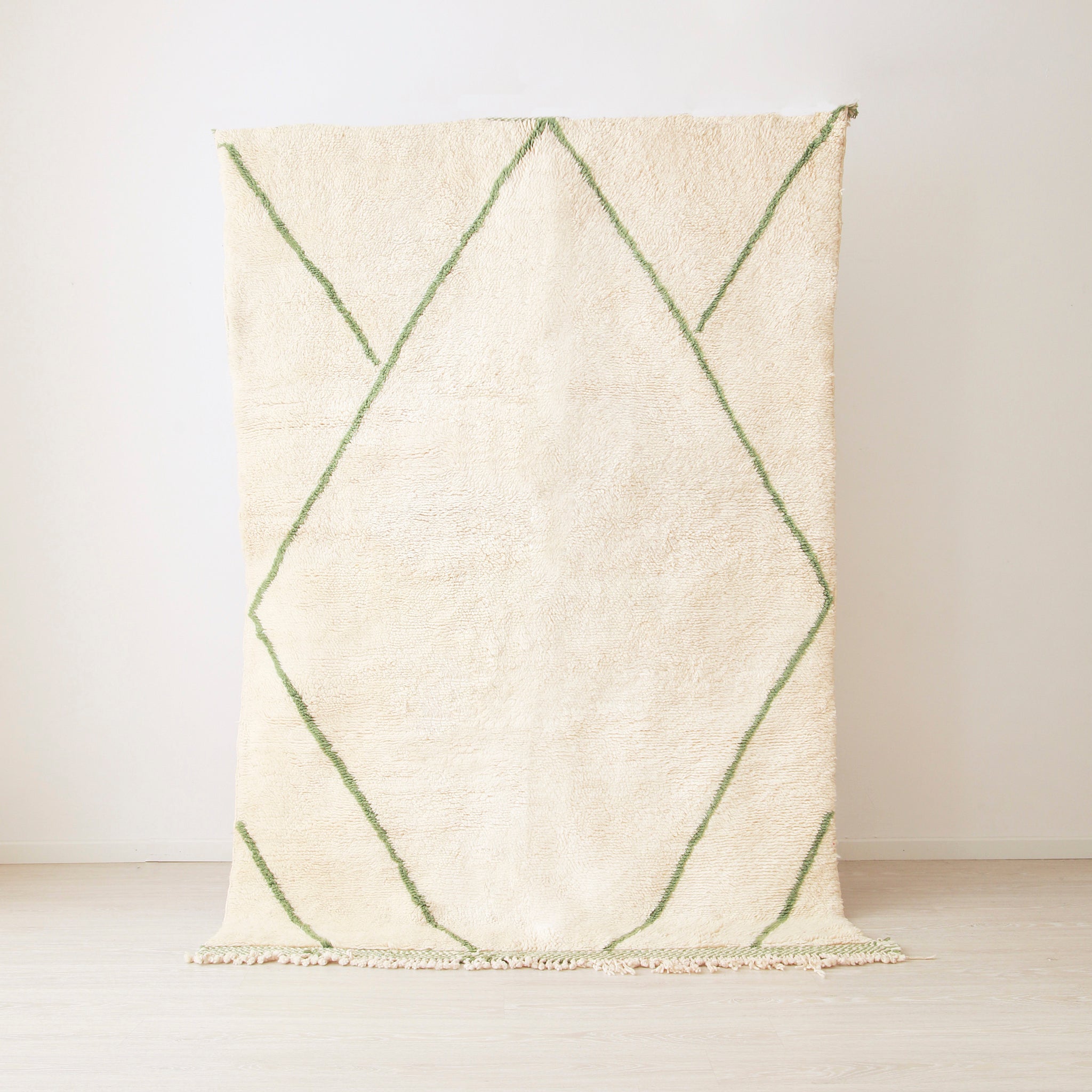 tappeto beni mrirt realizzato in lana bianca con linee verde. Le linee creano una grande rombo
