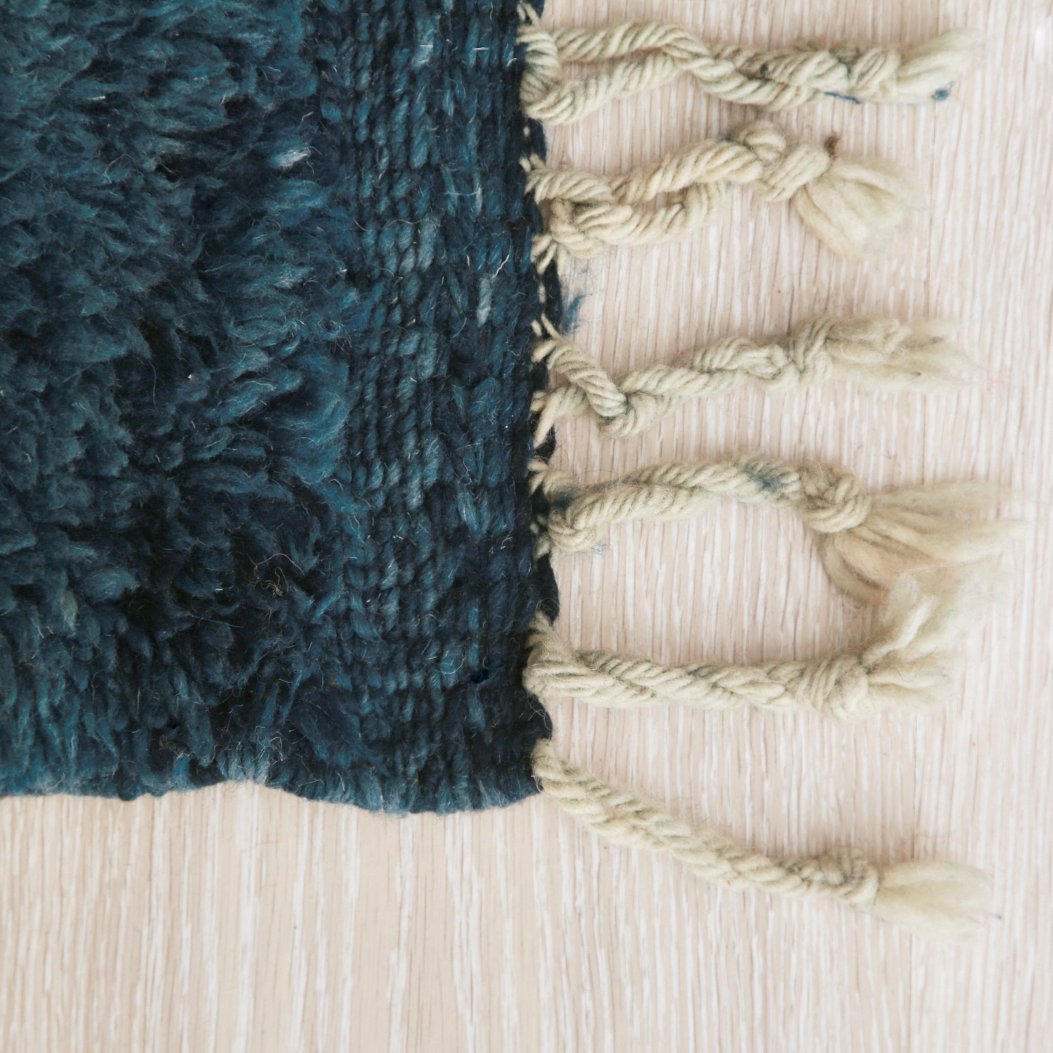 angolo di un tappet beni mrirt con lana tinta di blu scuro, anche il bordo della frangia è blu
