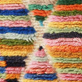 due linee bianche che si incrociano tra peli di lana di molteplici colori