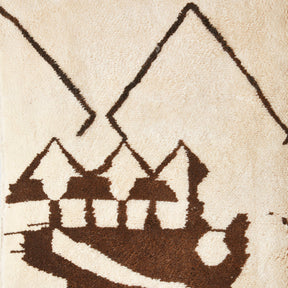 particolare dettaglio di un tappeto beni mrirt che mette in risalto dei disegni astratti raffiguranti le montagne e un le case di un villaggio