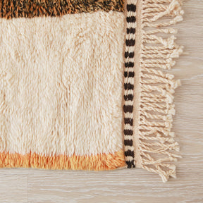 angolo dei un tappeto beni mrirt che mette in evidenza i peli di lana e sottile banda arancione sul bordo