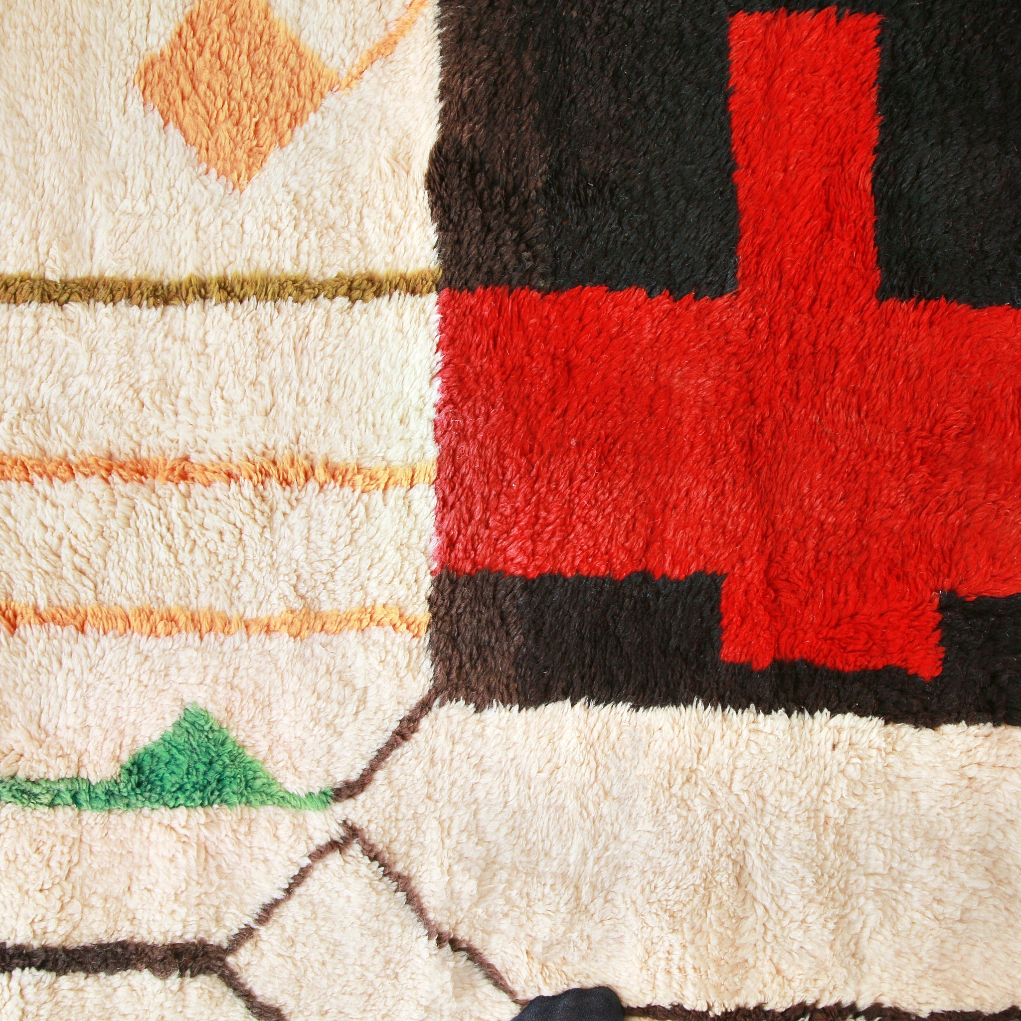 particolare della creatività di un tappeto beni mrir, linee dai colori pastello vere e araniconi e una coce rossa all'interno di un rettangolo marrone scuro