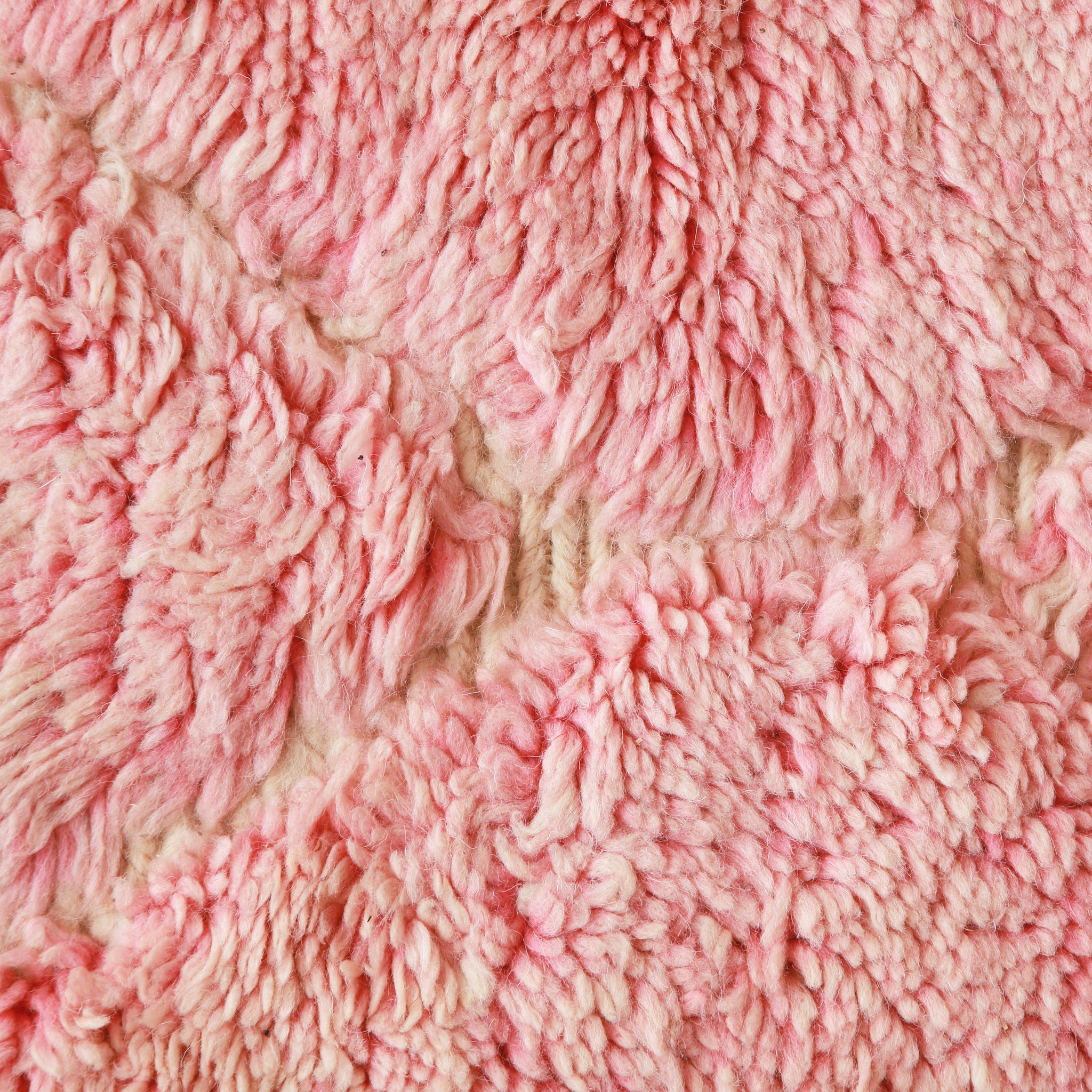 primo piano ravviciatano dei lunghi peli di lana rosa che evidenziano le sfurature di colore 