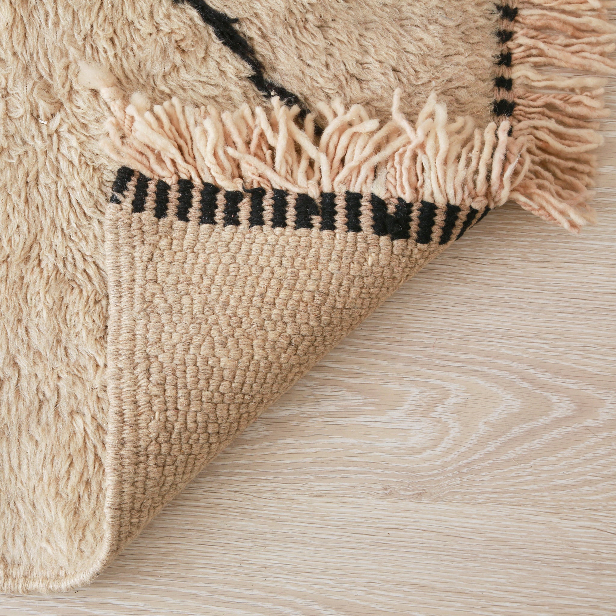 retro di un tappeto beni mrirt grigio per mettere in risalto la vicinanza e la precisione dei nodi, oltre che alle cuciture della frangia