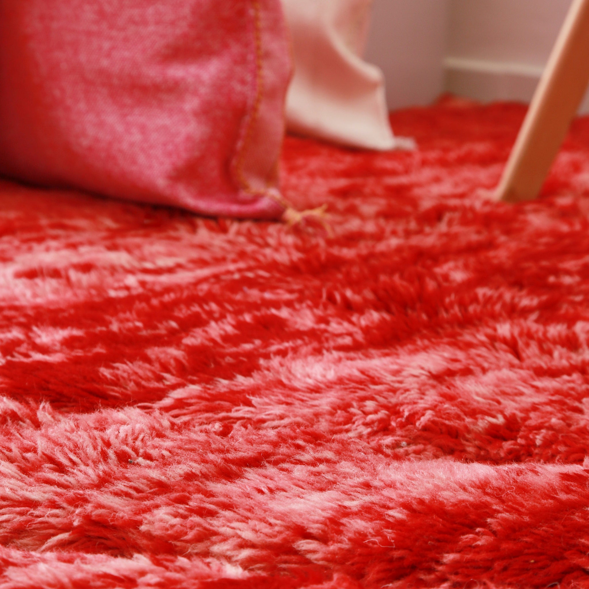 dettaglio dei lunghi peli di lana dalle sfumature di rosso fuoco di un tappeto beni mrirt