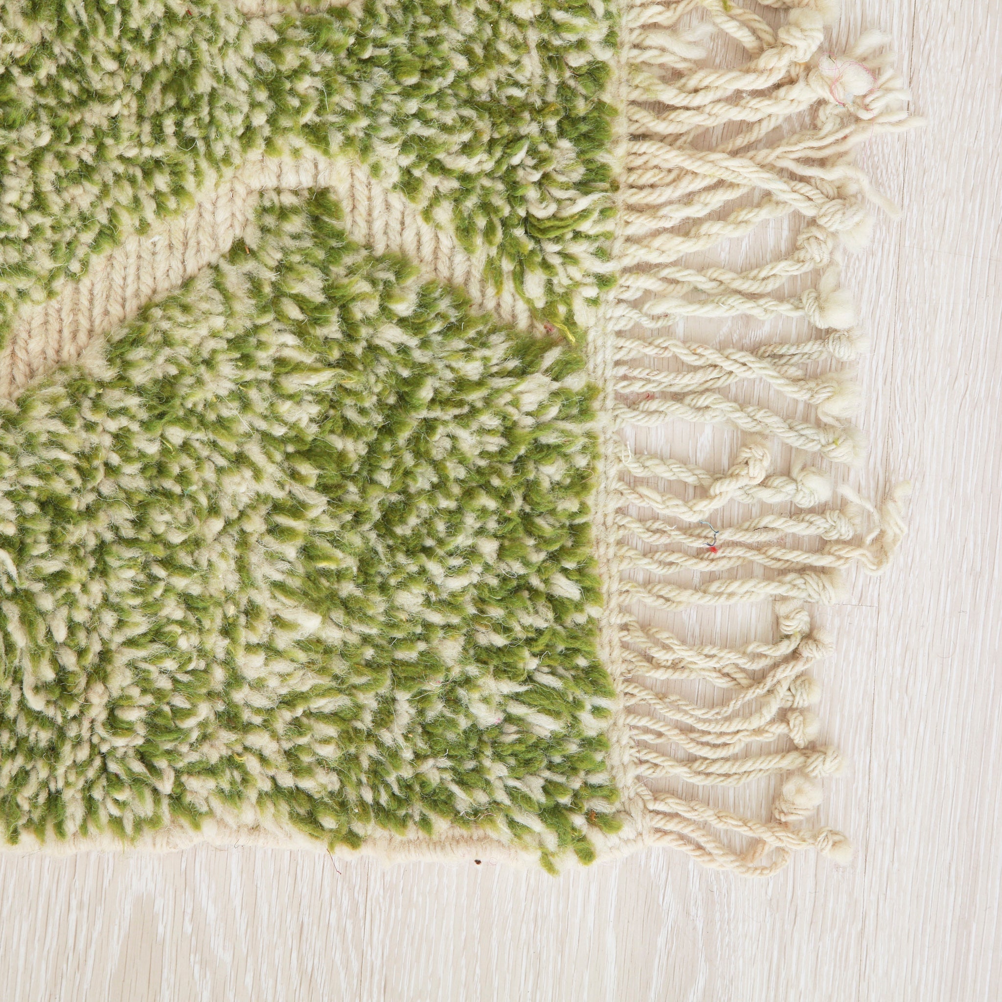 angolo di un tappeto beni mrirt realizzato a mano con lana in prevalenza verde