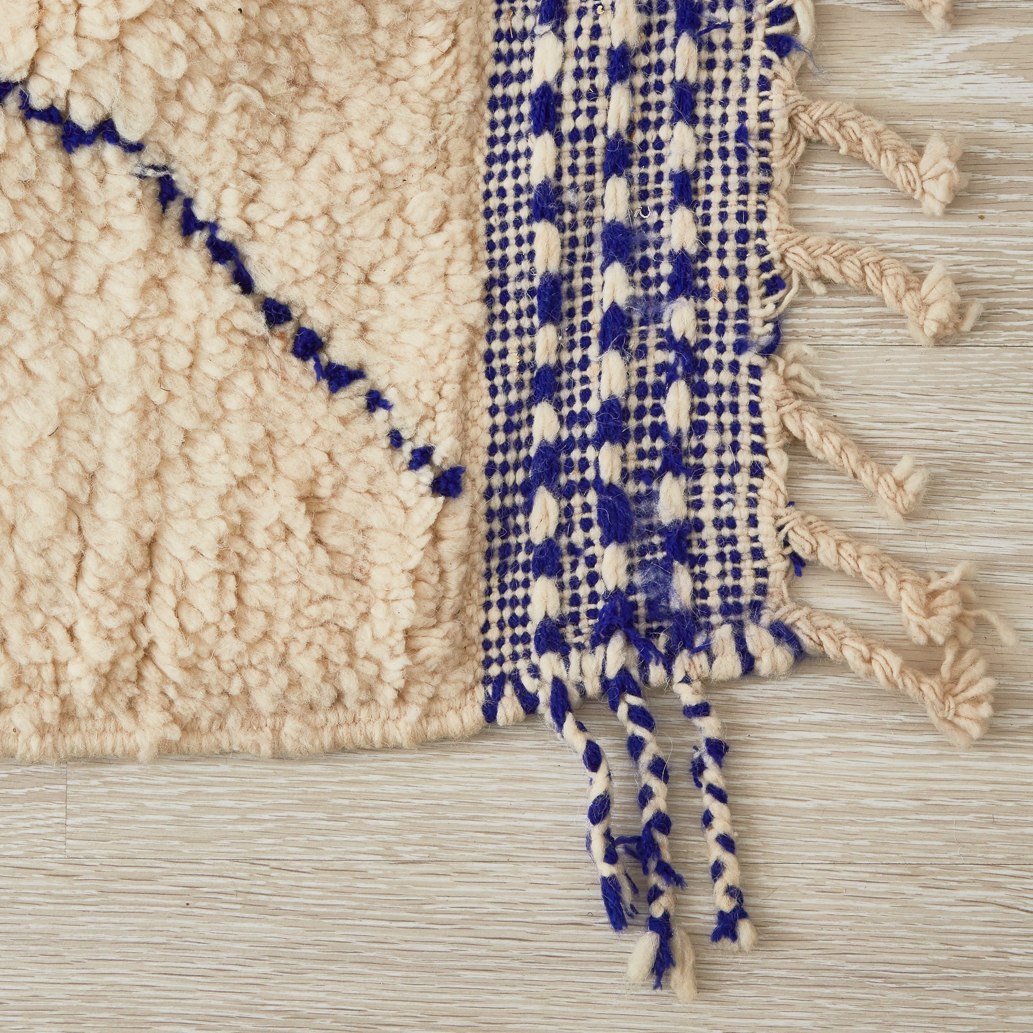 tappeto beni ourain bianco con rombi e lati corti blu dettaglio delle due frange