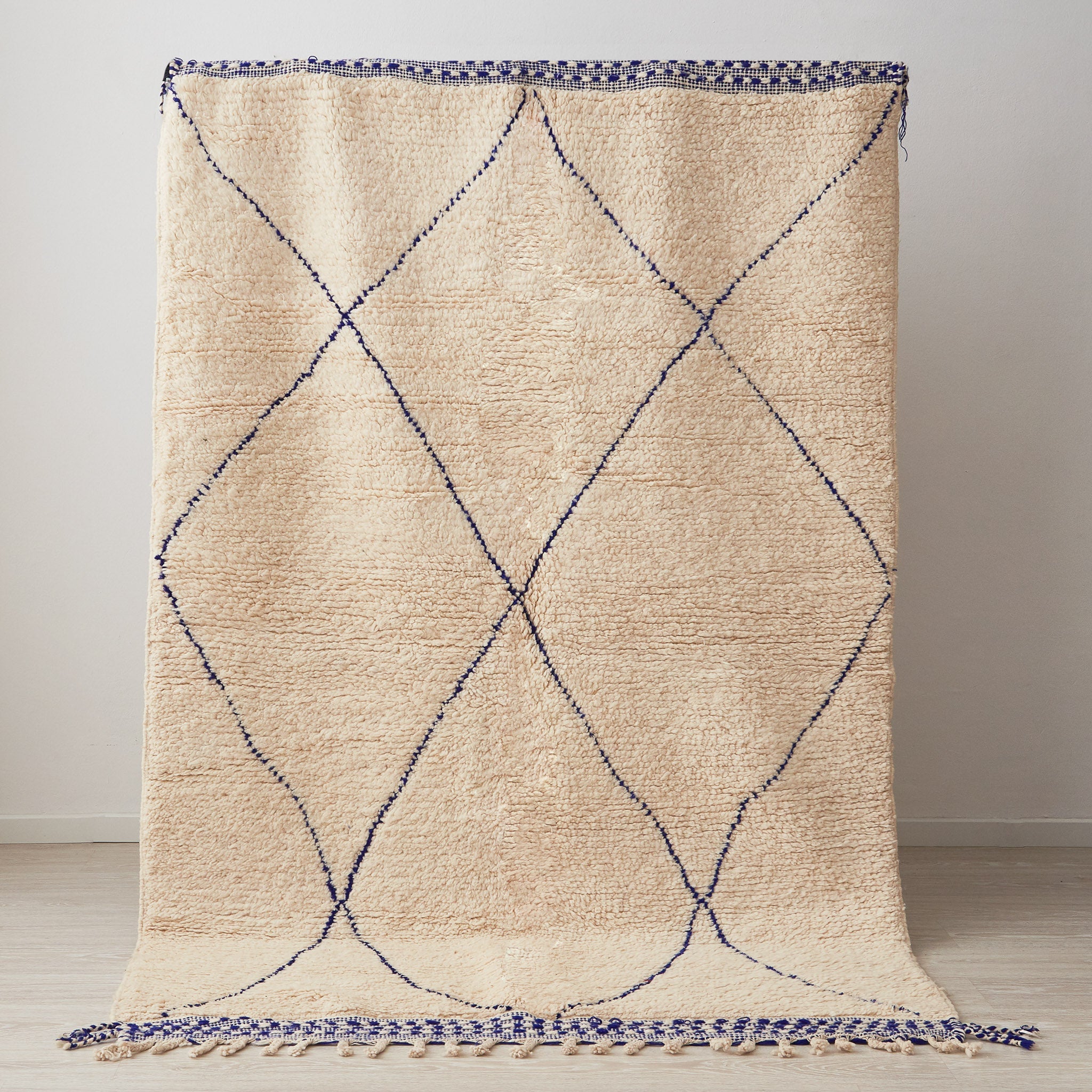 tappeto beni ourain bianco con rombi e lati corti blu posizionato in verticale