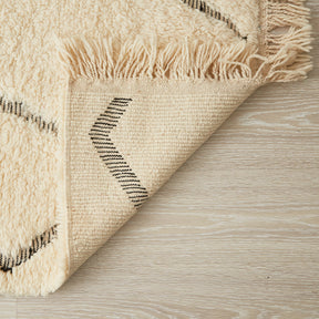 tappeto beni ourain con linee spezzate nere a pelo lungo bianco dettaglio retro